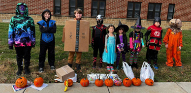 students in halloween costumes with pumpkins