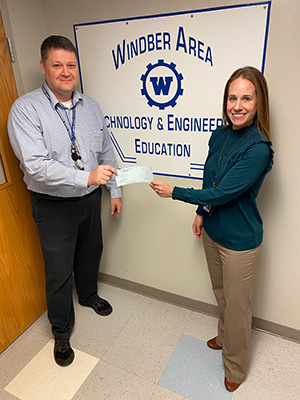 Middle School Principal Jessica Shuster presenting the check for the grant to David Dzurko, middle school technology education teacher.