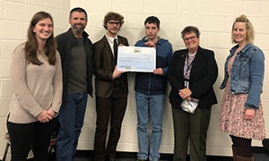 Aevidum Club receiving grant check