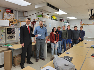 Joe Kush receiving grant with students in classroom