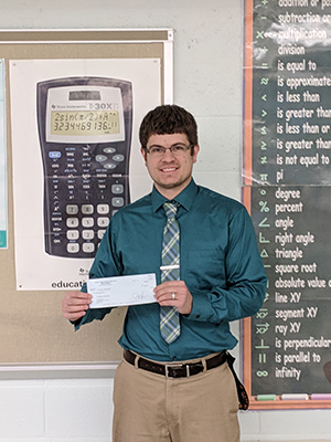 Christian Sevinsky holding his grant check