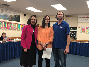 Jamie White stands with Superintendent Karen K. Voigt and Jason Richmond, School Board President