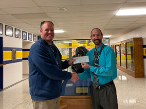 Mr. Greco (on the left), a biology teacher at Saegertown High School, receives a check from Principal Tom Baker