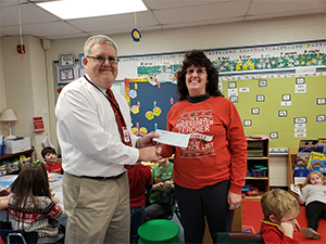 Mrs. Mary Stanko receives her check from the superintendent.